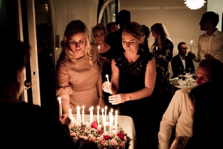 Friends adding some candles to a birthday cake